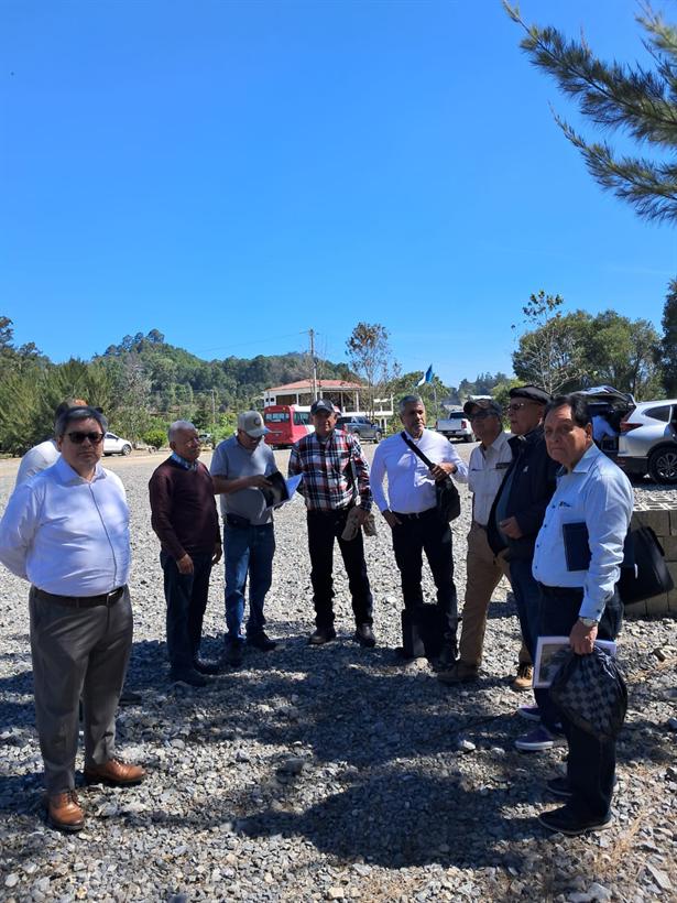El grupo de pie en el terreno donado, bajo el cielo despejado